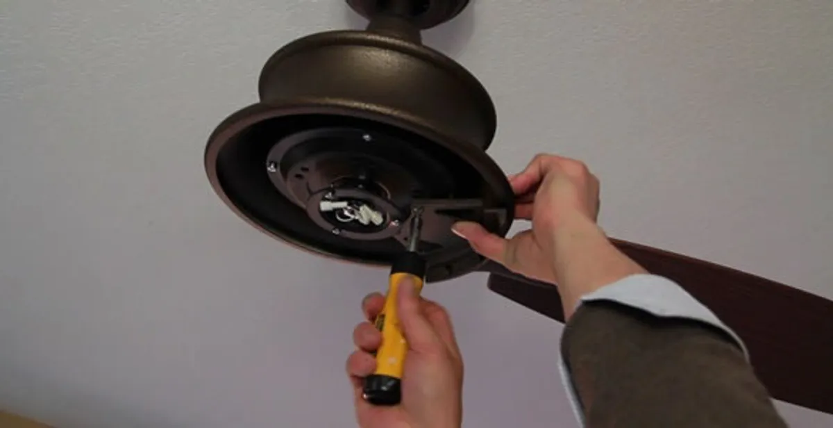 Electrician installing ceiling fan mounting bracket and fixture in Allentown, PA